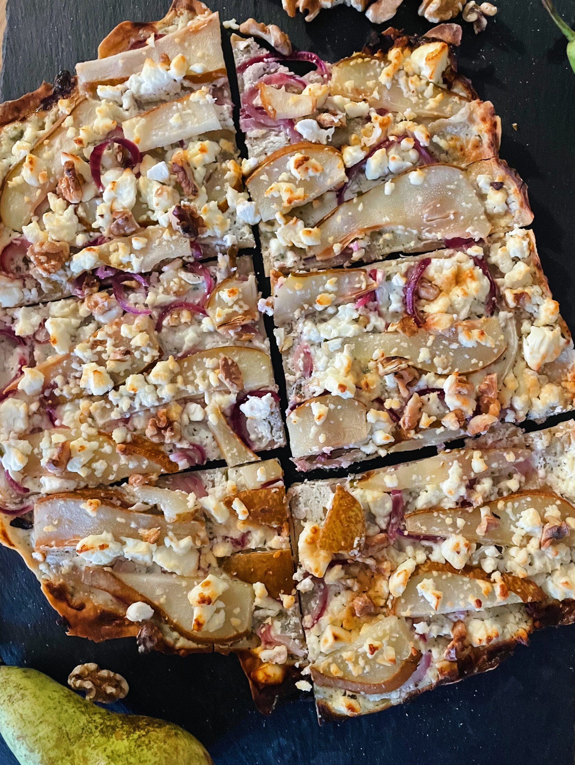 Ansprechendes Bild von einem Flammkuchen mit Birnen und Feta-Käse belegt