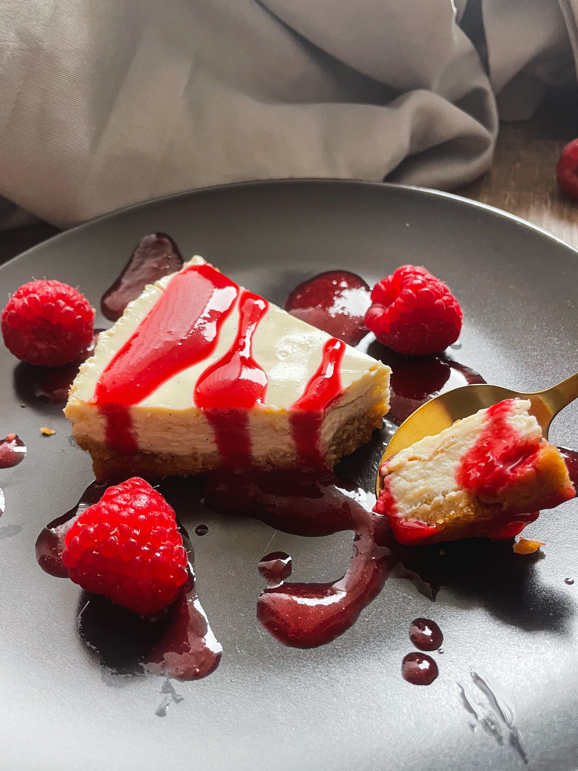 Lecker angerichteter cremiger veganer Cheesecake mit Himbeeren